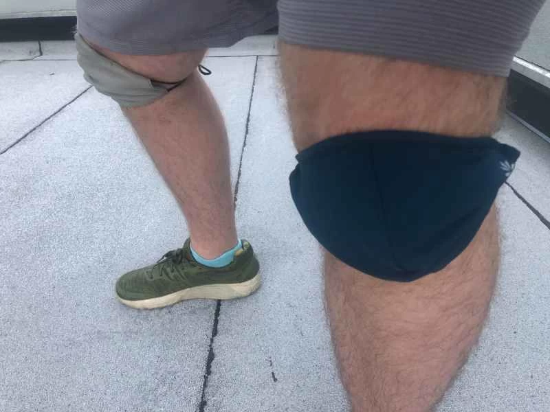 一名男子身穿短褲、運動鞋，並將布口罩當作護膝。