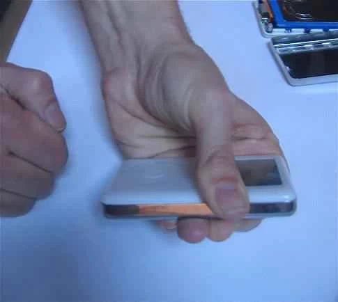 一個人拿著iPod放在白色桌上。