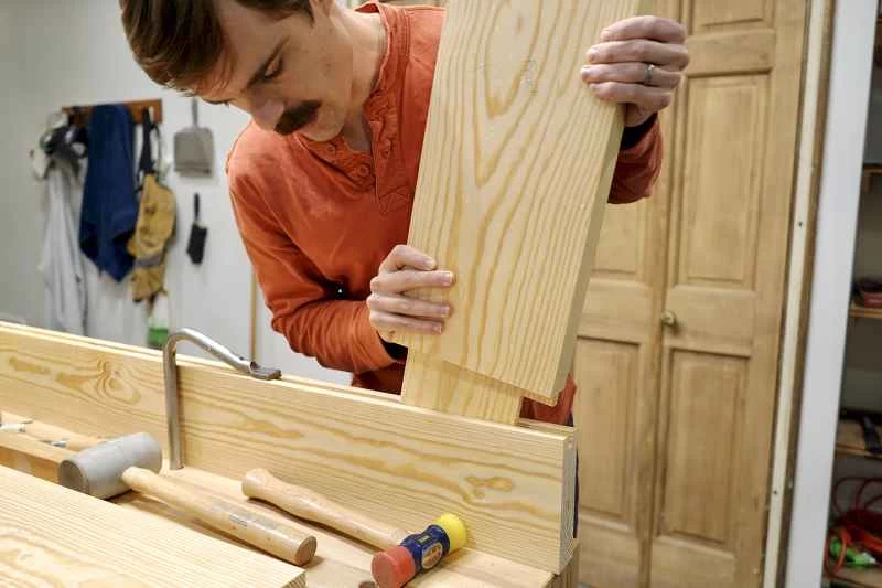 正在安裝榫接結構的工人，這是建造外門的一部分。