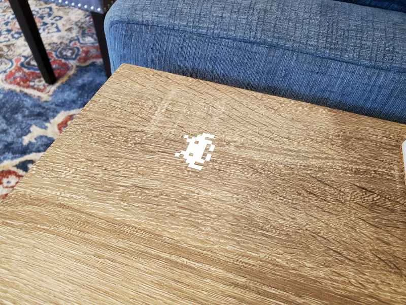 桌上貼著太空侵略者貼紙，桌子內建無線充電功能