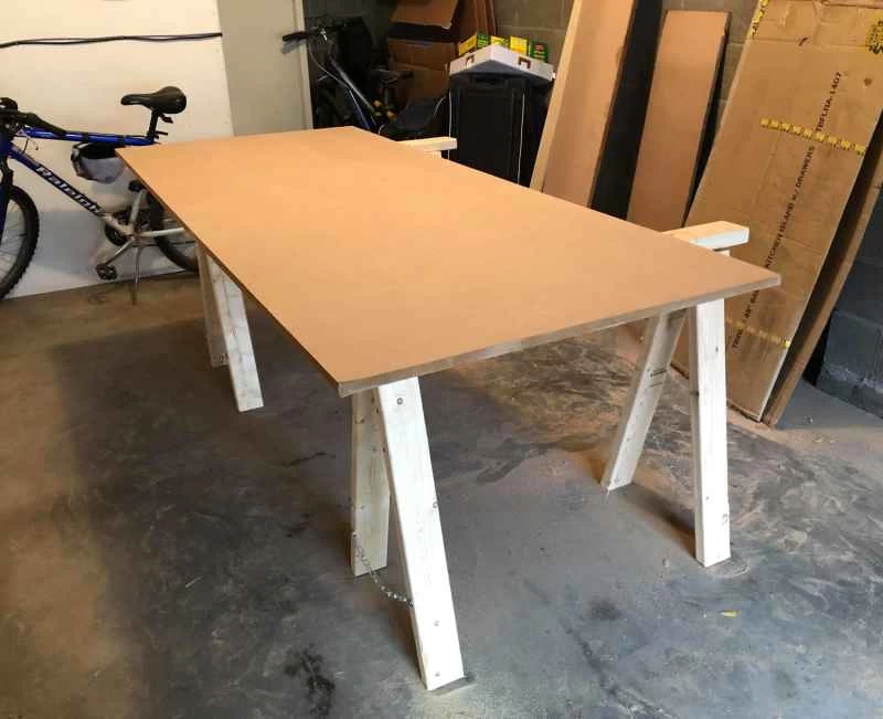 車庫裡，兩根鋸木架上放著一塊中密度纖維板。