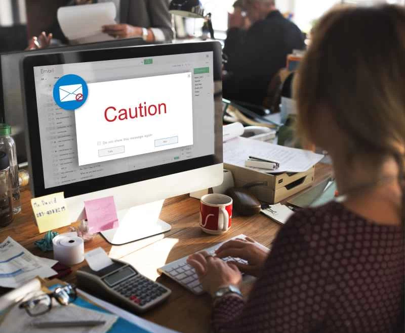 一位女士坐在電腦前，發出謹慎的建議。