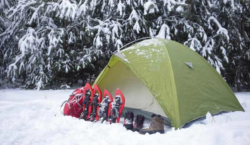 冬季露營活動，穿著雪鞋，帶著帳篷。