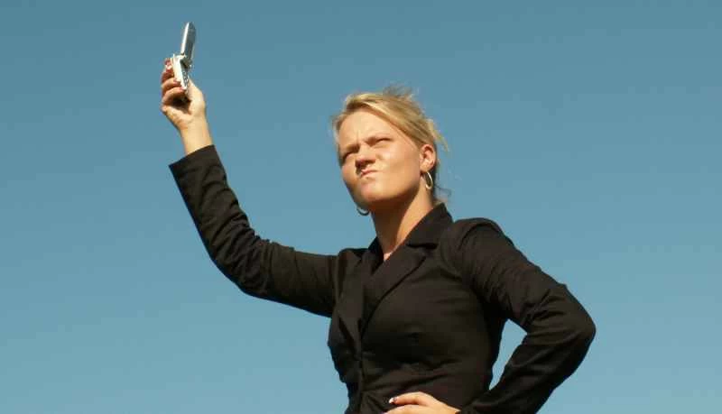 惱怒的人正在手機上搜尋訊號